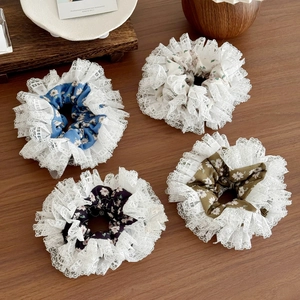 Set of 4 floral lace scrunchies in blue, white, black and green on wooden background