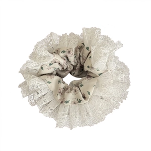 Floral print hair scrunchie with layered lace edges on a clean white background