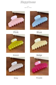 Collection of six colorful rhinestone-studded acetate claw clips on dark wood background