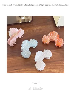 Detail view of colorful shell-shaped acetate hair claws with pearls and size measurements