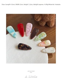 Detailed view of 4mm thick marble texture acetate hair clips on a white circular stand