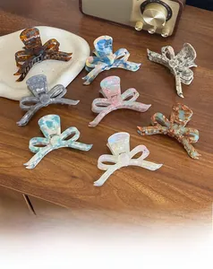 Detail of eight bow-shaped acetate hair claws with marble and tortoiseshell patterns