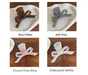 Detail view of acetate butterfly hair claws in four colors with gold logo