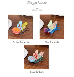 Detailed view of acetate butterfly hair clips in brown, blue, and green colorways