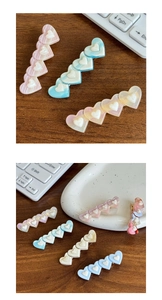 Détail de barrettes à cheveux en acétate en forme de cœur aux couleurs acidulées