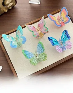 Detail shot of five colorful butterfly hair claws with hand-painted texture on a wooden tray