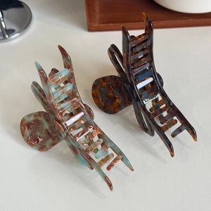 Elegant marble and tortoiseshell acetate hair claws with premium gold logo details