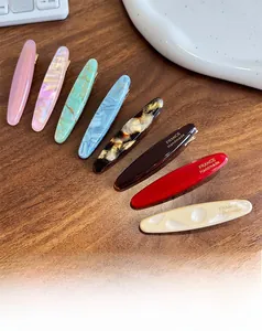 Close-up of handmade acetate hair clips in eight patterns with gold metal base
