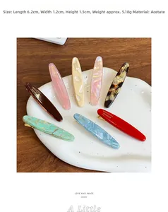 Macro shot of colorful acetate hair clips on a white ceramic tray measuring 6.2x1.2x1.5cm