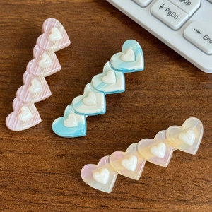 Barrettes à cheveux en acétate en forme de cœur rose et bleu sur fond de bois sombre