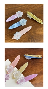 Detail view of 4-pack flower duckbill hair clips in pastel pink, blue, purple, and yellow
