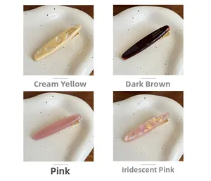 Detail showing acetate duckbill hair clips in cream, coffee, pink, and pearl colors