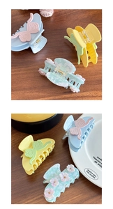 Dettaglio di fermagli per capelli macaron con fiori e fiocchi su un piatto di ceramica