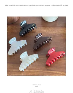 Detailed view of medium acetate hair claw clips with gold logo and 8.5cm size dimensions