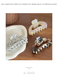 Macro view of large acetate floral hair claw clips in spotted and tortoise shell patterns