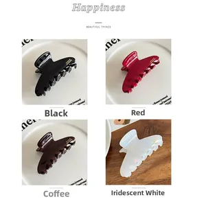 Detail view of acetate hair claws in black, red, brown and white with gold label