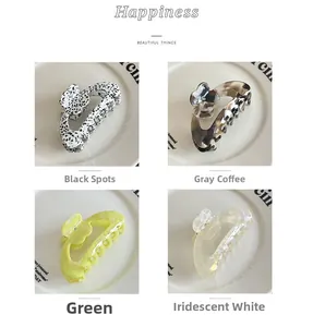 Detail view of four acetate floral hair claws in leopard, marble, green and pearl white