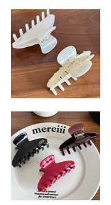 Detail of handmade acetate hair claws with gold-stamped France logo on various surfaces