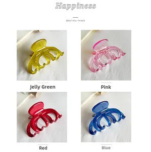 Detail view of large acetate claw clips in translucent green, pink, red, and blue colors