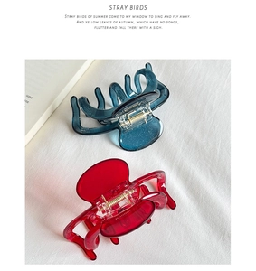 Detail of dark blue and bright red glitter acetate hair claws with durable metal springs