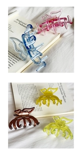 Detail of elegant jelly-colored butterfly hair clips with golden label and resin finish