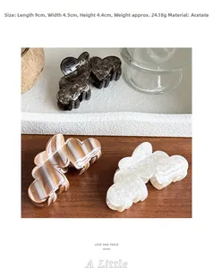 Three acetate heart hair claws in tortoiseshell and cream stripes on a white tray