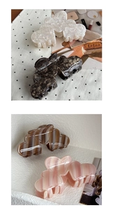 Macro view of heart-shaped acetate claw clips in four striped and tortoiseshell patterns