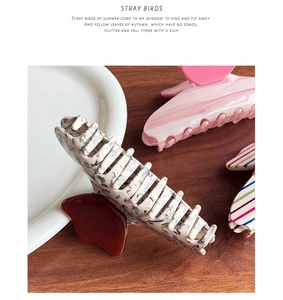 Macro detail of large acetate hair claws with colorful marble patterns and glossy finish