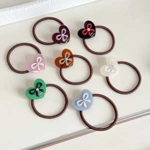 7-piece set of heart-shaped bow hair ties in assorted colors with rhinestone accents