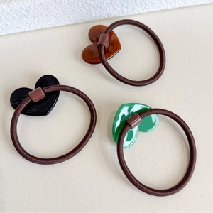Three-piece vintage heart elastic hair ties in black, amber brown, and emerald green finish