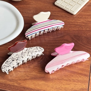 Three elegant acetate hair claw clips with colorful stripes and marble patterns