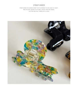 Macro shot of acetic acid hair claw clip with colorful marble texture and gold metal spring