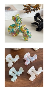 Detailed display of acetic acid shark clips in marble, tortoiseshell, and pearlescent finishes