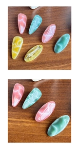 Detailed view of resin hair clips with cat eye texture and silver metal duckbill base