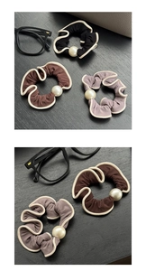 Detail of wavy pleated hair scrunchies in various colors with a large central pearl accent
