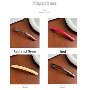Detailed macro view of four acetate spring hair clips in various marble and floral patterns