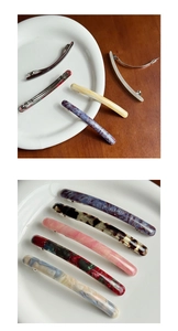 Detailed macro view of assorted acetate spring hair clips in various marble patterns