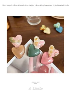 Détail de la pince à cheveux cœur en résine avec fleurs séchées, dimensions 4,3x2,5 cm