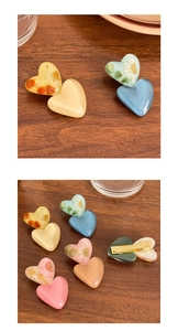 Vue détaillée des pinces à cheveux en cœur avec fleurs séchées en résine transparente