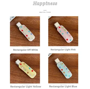 Macro shot of rectangular acetate hair clips with colorful rhinestones on wood