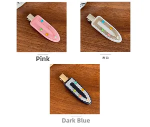 Close-up of acetic acid hair clips in pink, beige, and blue with embedded rhinestones