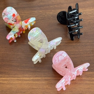 Set of four medium acetate claw clips in black, marble pink, pearl white, and floral patterns