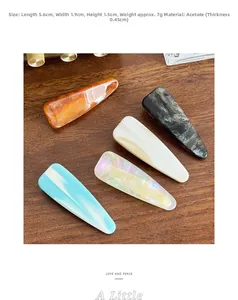 Detailed view of 5.6cm acetate hair clips in amber and pearl patterns on wood