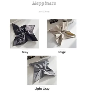 Detail of striped and plaid scrunchies with heart pendants in grey and beige tones