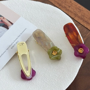 Schicke Acetat-Haarklammern mit Strass-Blumenmustern auf weißem strukturiertem Grund