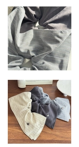Close-up of striped fabric scrunchies with heart-shaped metal charm and texture detail