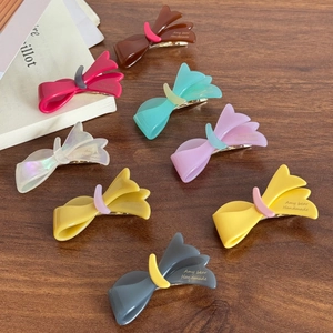 Elegantes Set mit 8 bunten Azetat-Schleifen-Haarspangen für Damen auf einem Holztisch