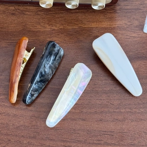 Set of four minimalist acetate hair clips in amber, marble, and pearl textures
