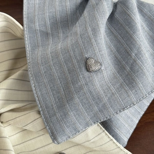 Striped fabric hair tie with elegant heart-shaped metal accent and premium texture