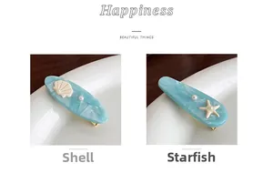 Detailed view of light blue shell and starfish hair clips with pearl accents